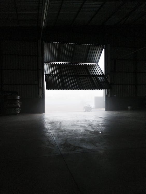 Inside of a spacious garage with a half-open door