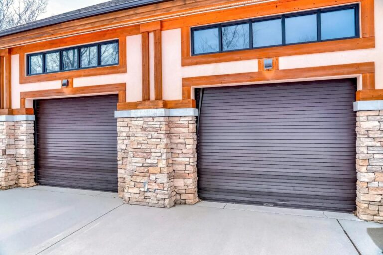 Two grey garage doors of a garage with windows on top