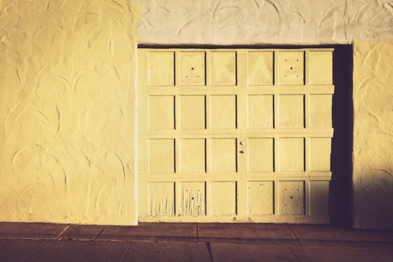 A weathered white wooden garage door showing signs of aging and wear.